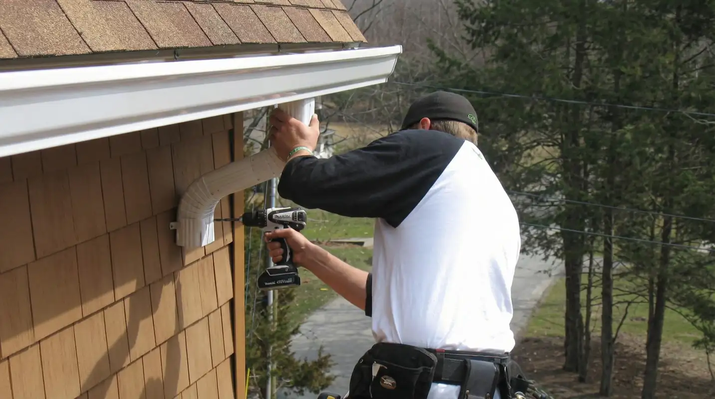 Professional contractor installing tan vinyl siding panels on a residential home exterior in San Antonio, TX
